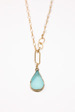 Aquamarine teardrop druzy with tiny quartz necklace flat lay.