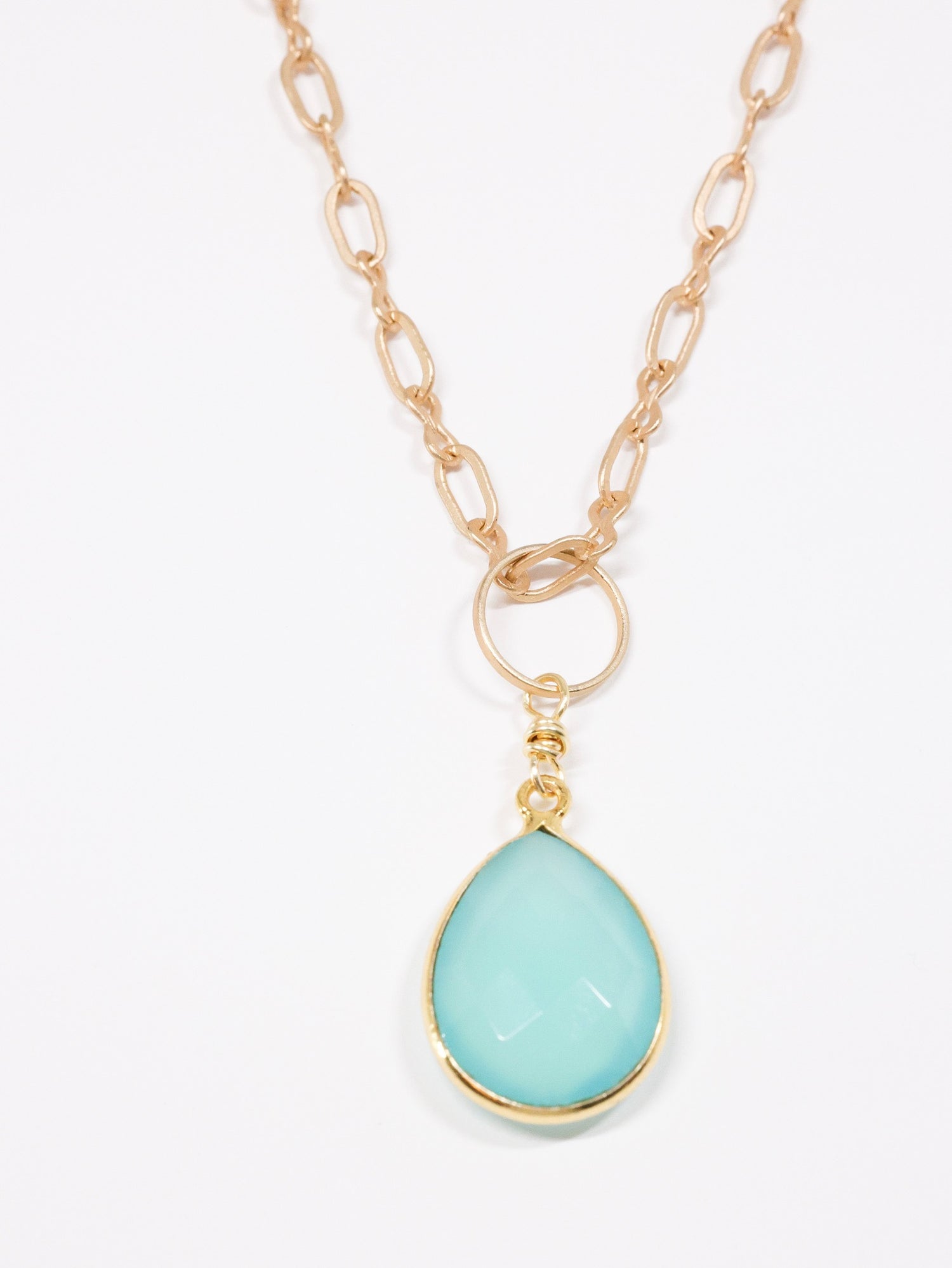 Peruvian chalcedony teardrop matte gold necklace on flat lay 