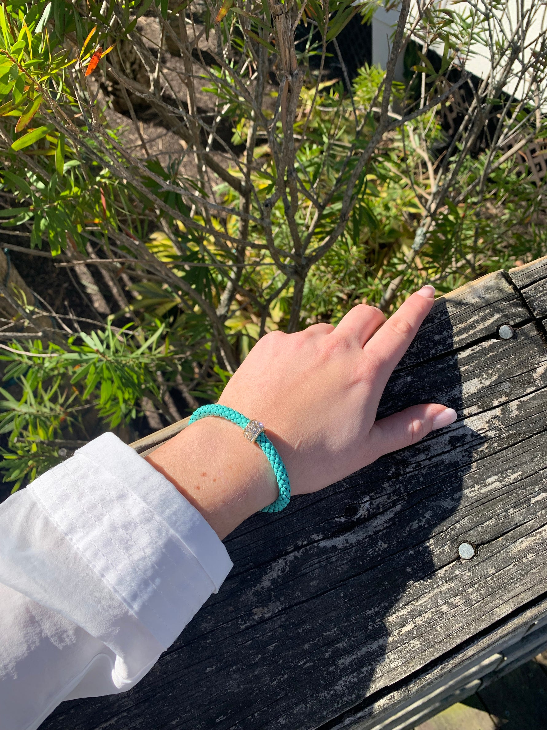 Scarlett stretchy bracelet in teal on model.