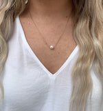 simple gold chain necklace with a pearl in the center